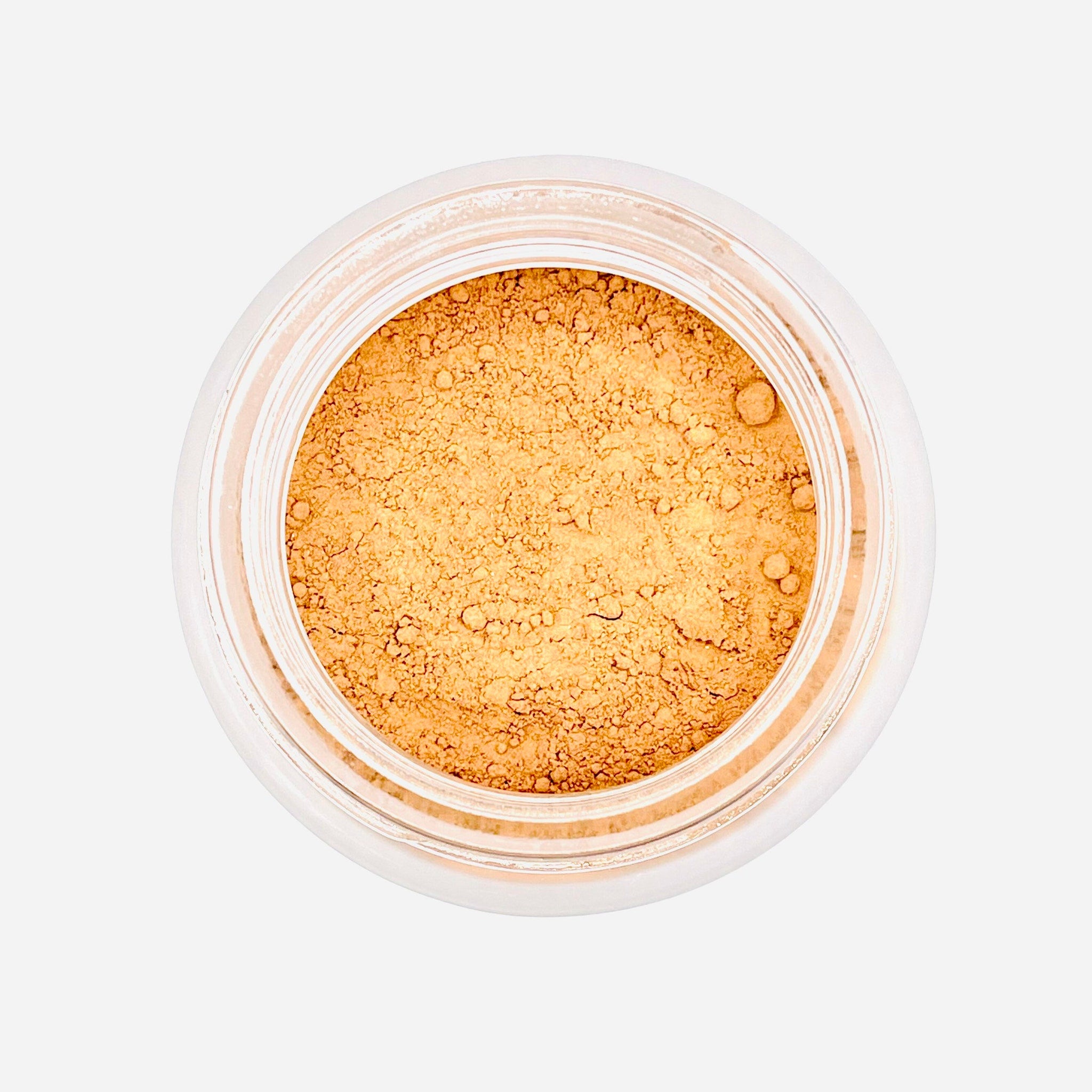 Face powder in light brown color, in a clear plastic container, product view from above