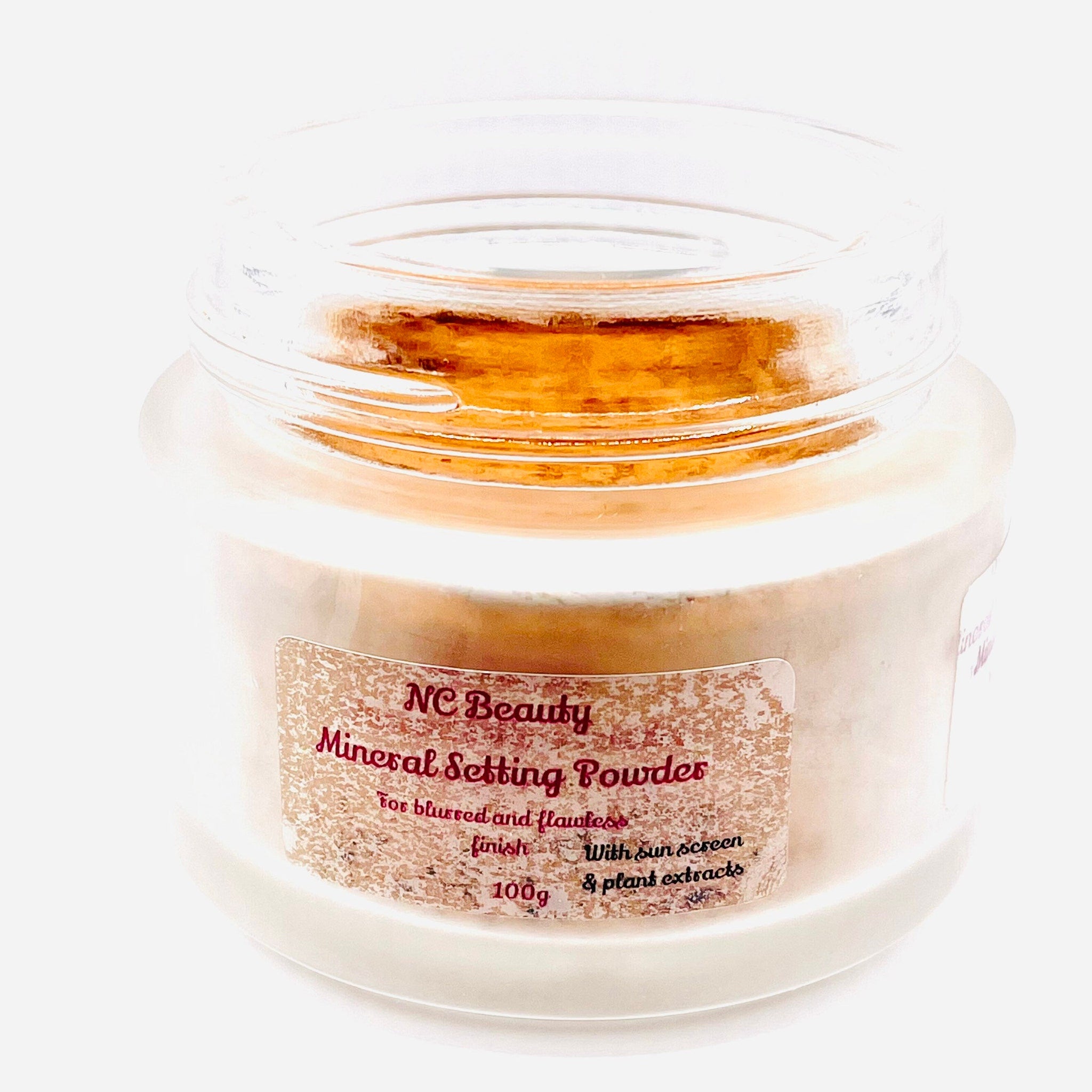 Mineral setting powder in a clear glass jar with a tan powder and a label that says NC Beauty