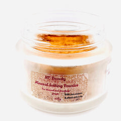 Mineral setting powder in a clear glass jar with a tan powder and a label that says NC Beauty