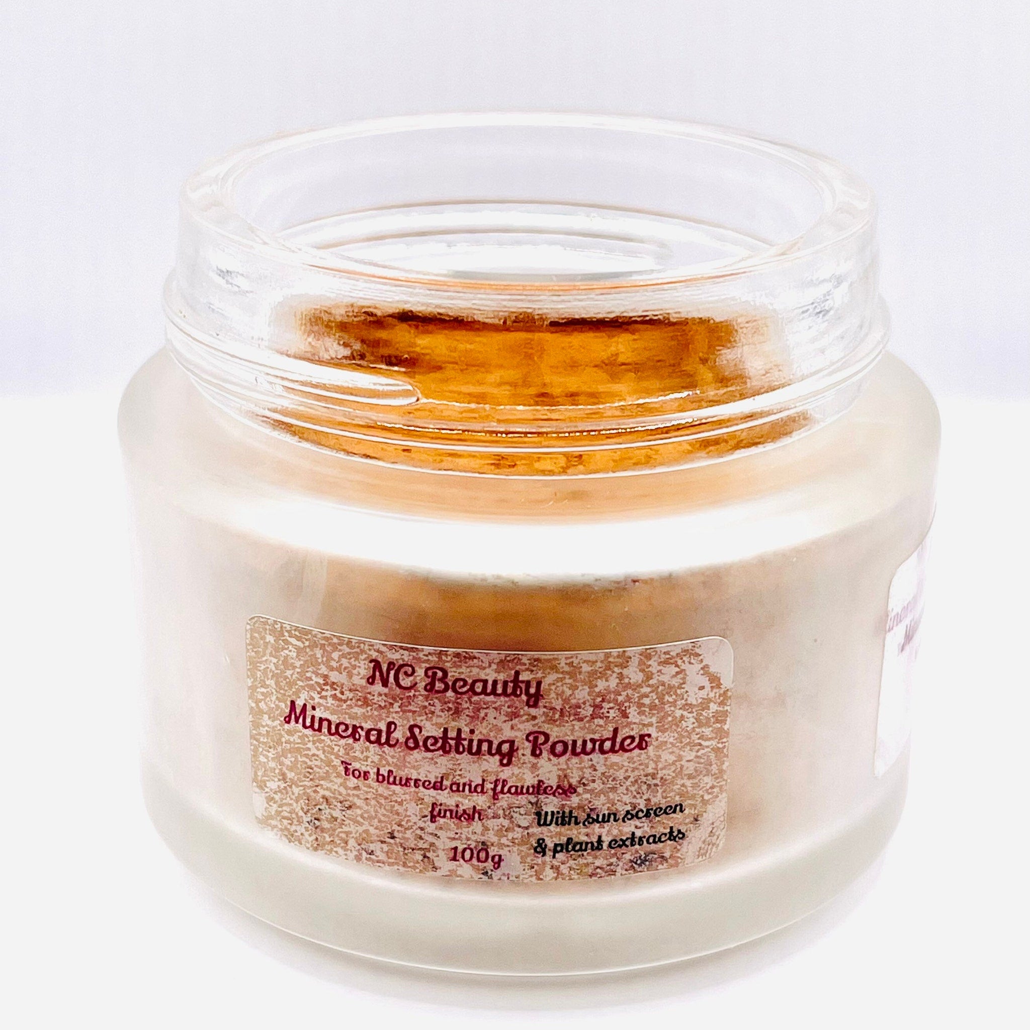 Mineral setting powder in clear glass jar with beige powder and NC Beauty label
