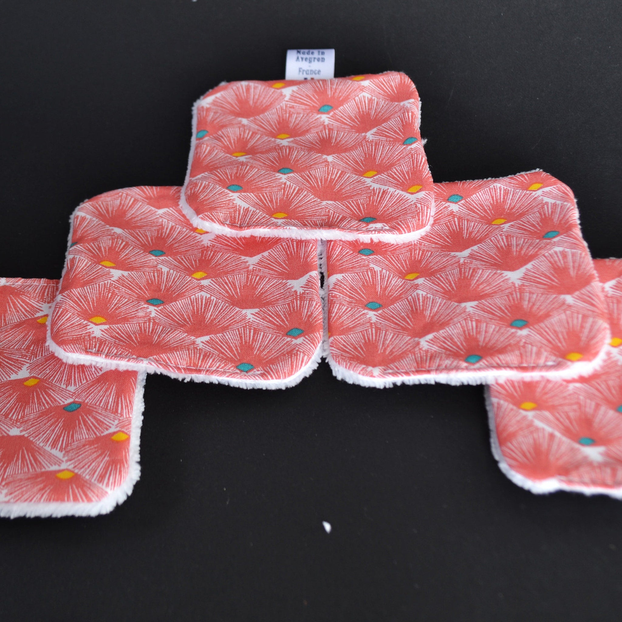 Reusable facial pads with red floral pattern, white trim, and "Made in Avegrom France" tag