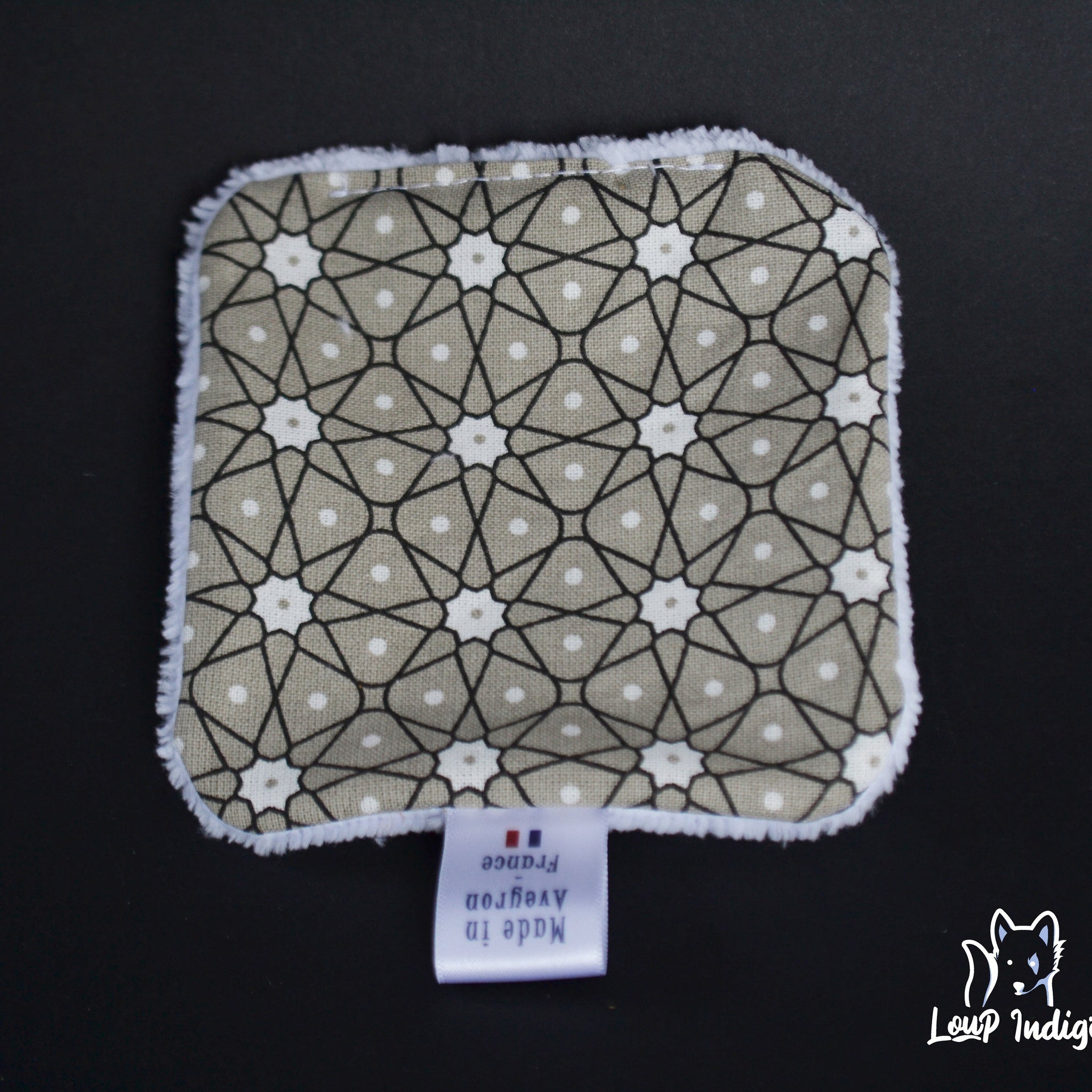 Reusable pad with geometric pattern, tan and white, with white trim and Loup Indigi logo