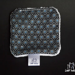 Black patterned fabric with white trim and Loup Indigo label, geometric design