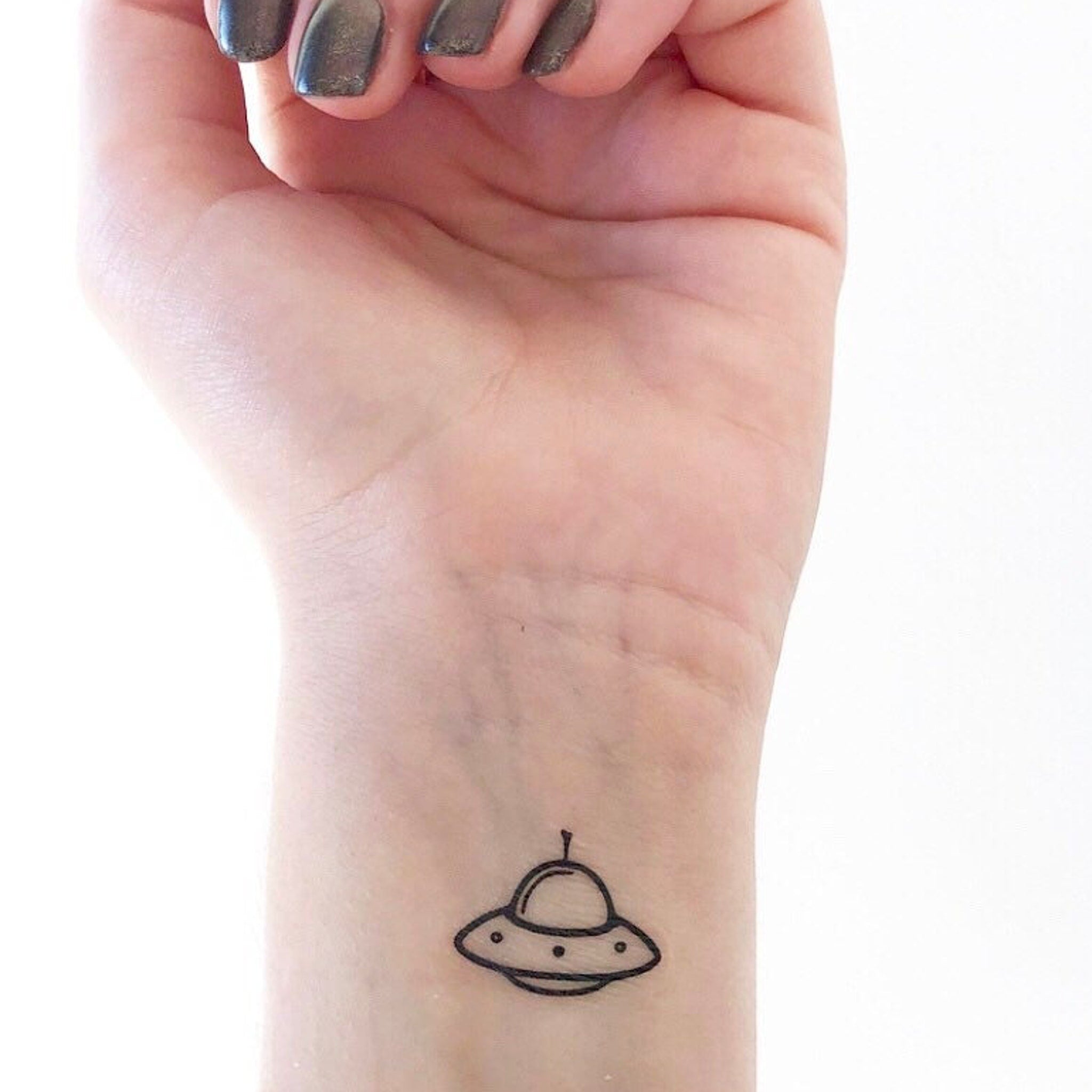 Two skin-safe temporary tattoo UFO sets in sleek silver packaging with cosmic-themed designs