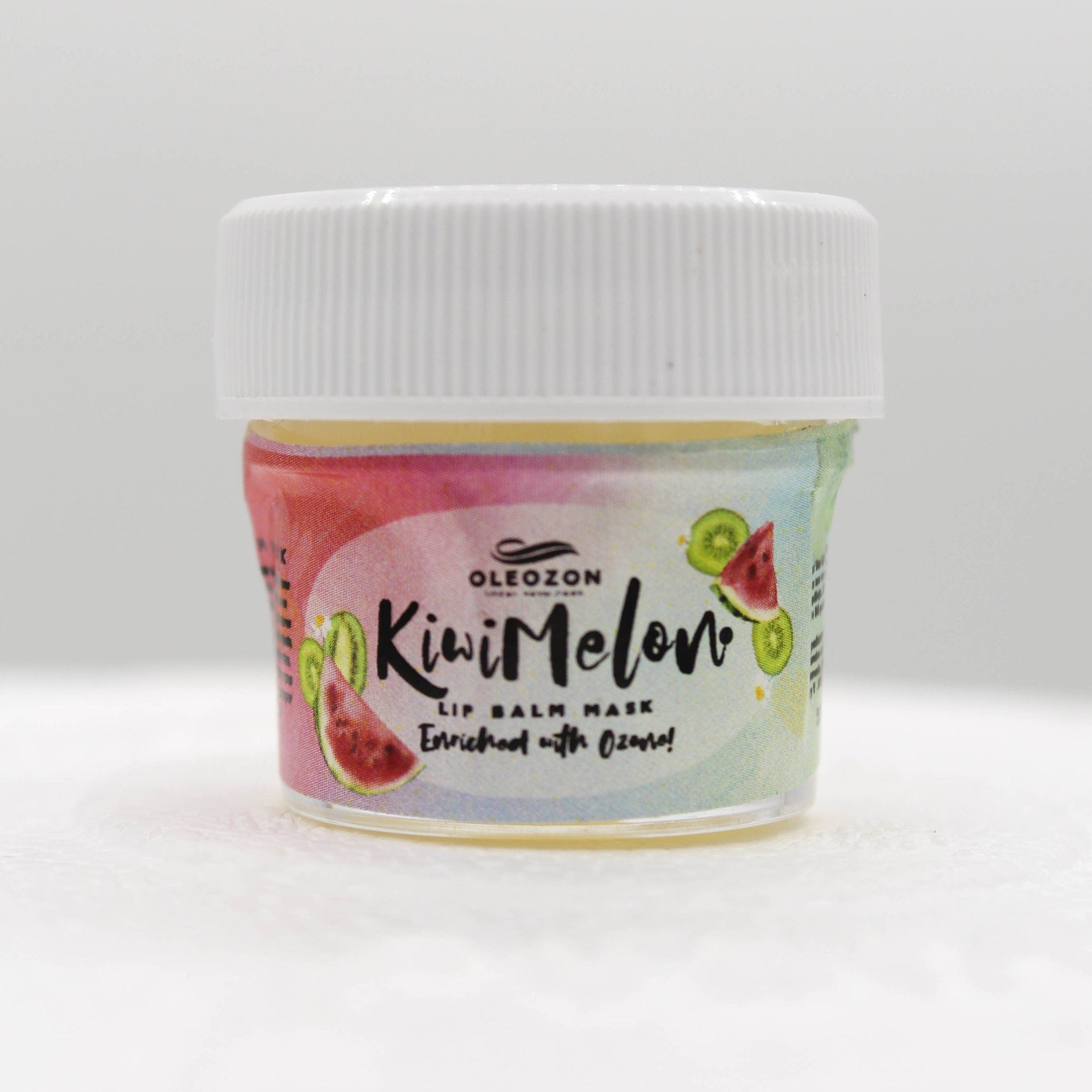 Lip balm mask with white lid, colorful label with "Kiwi Melon" text, and fruit illustrations