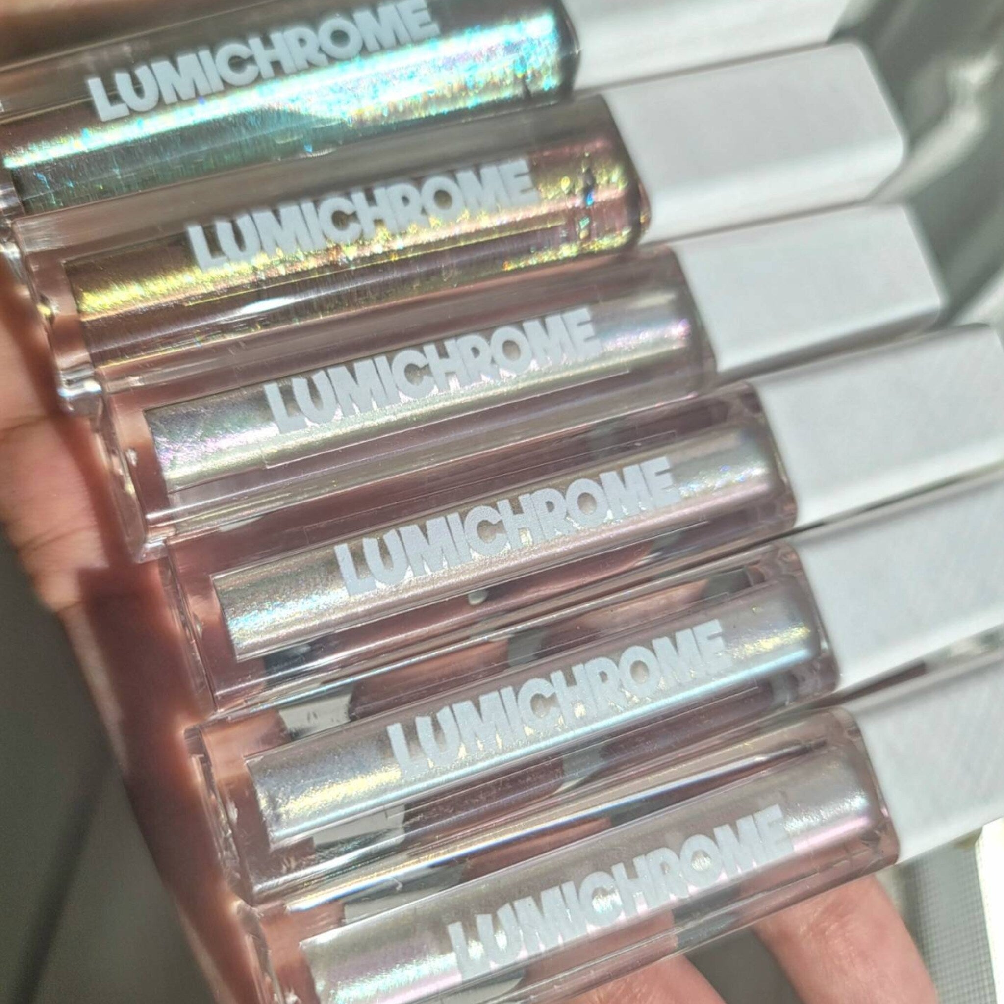 Close-up of chameleon duochrome liquid eyeshadows showing iridescent shift in three shimmering vegan shades