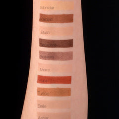 Close-up of golden brown matte eyeshadow being applied to eyelid with a fluffy brush