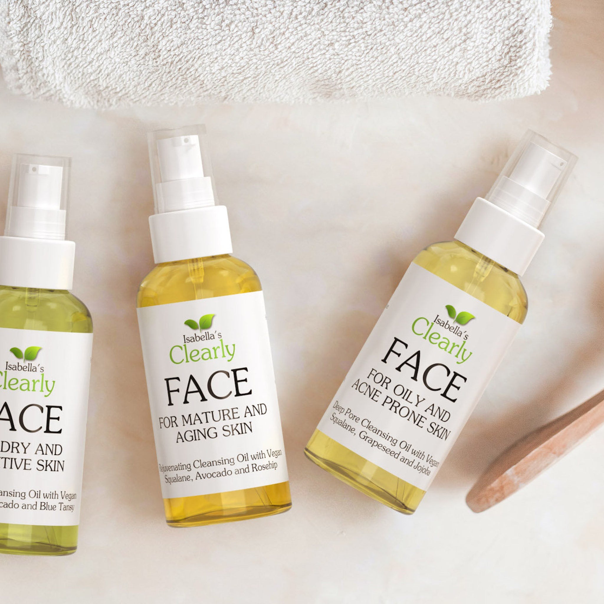 Face cleansing oil bottles, clear glass, white label, Isabella's Clearly brand, yellow liquid inside, white background