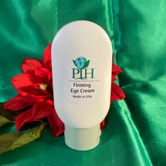 Eye cream bottle, white plastic, Progress Organic Natural label, on green fabric with red flower