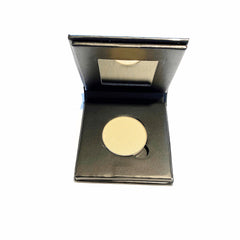 Close-up of vibrant lemon yellow mineral eye shadow in a natural paperboard compact, showing powdery texture