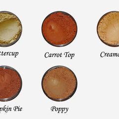 Side view of warm brown and orange eye shadow palette showing textured powder surfaces and compact case design