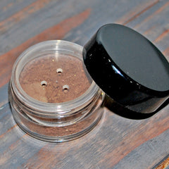 Close-up of warm brown and orange eye shadows applied to eyelids with a blending brush for a gradient effect