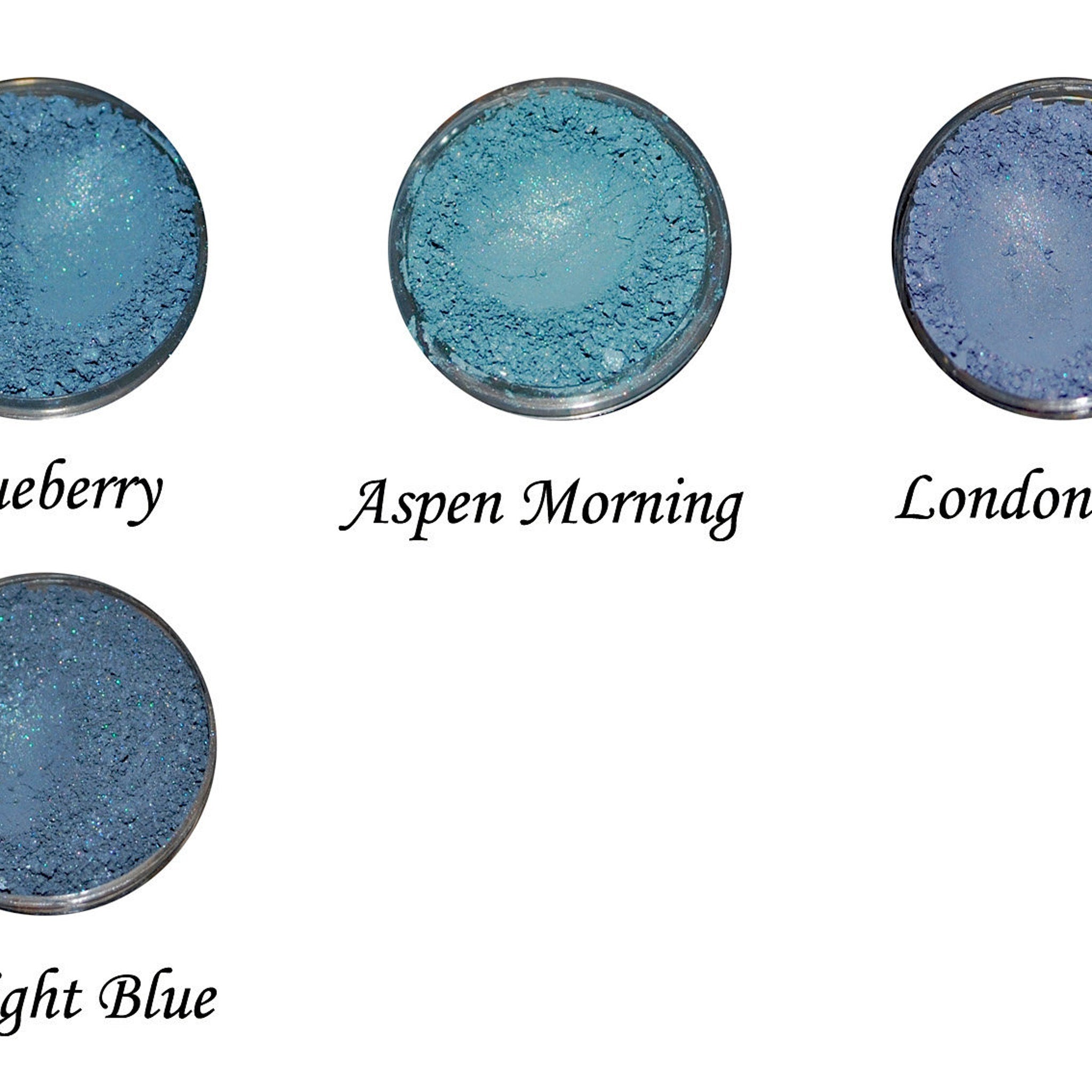 Close-up of vibrant blue and green eye shadow palette with shimmering metallic finish and smooth powder texture