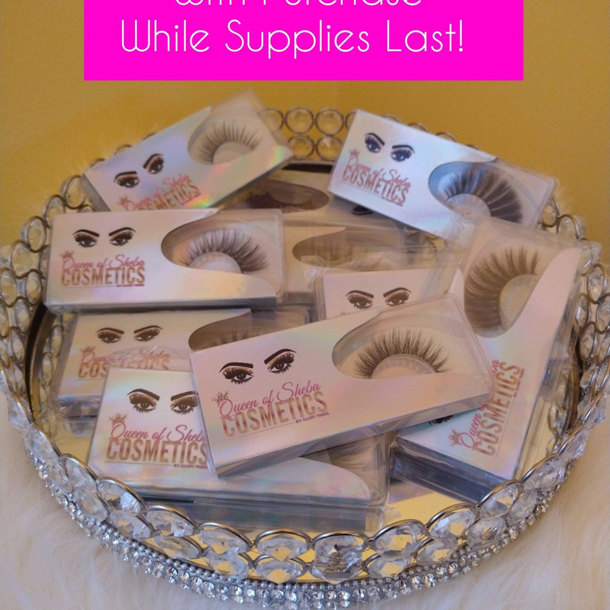 False eyelashes in clear plastic packaging with Queen of Sheba Cosmetics brand name on a mirrored tray