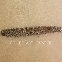 Side angle view of matte espresso brown eye shadow in compact with mirrored lid and brand logo.