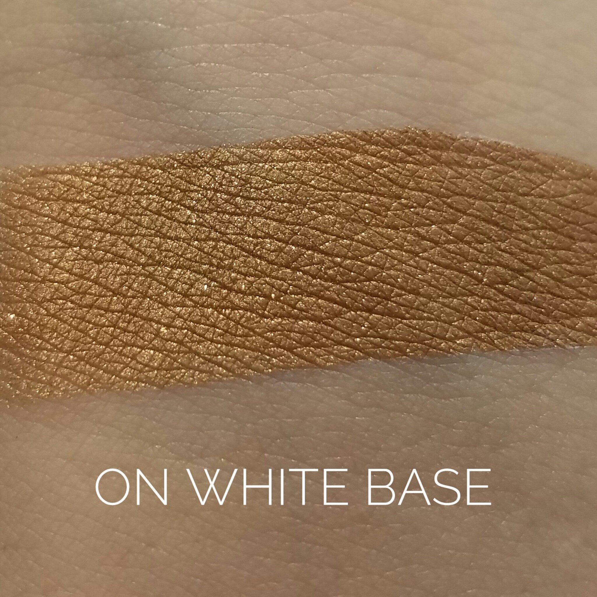 Close-up of warm copper eye shadow with metallic shimmer in compact pan