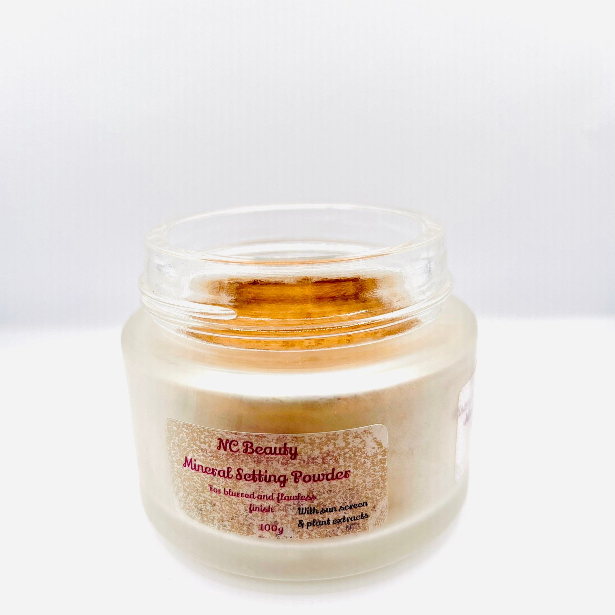 Mineral setting powder in a clear glass jar with a label, NC Beauty branding visible