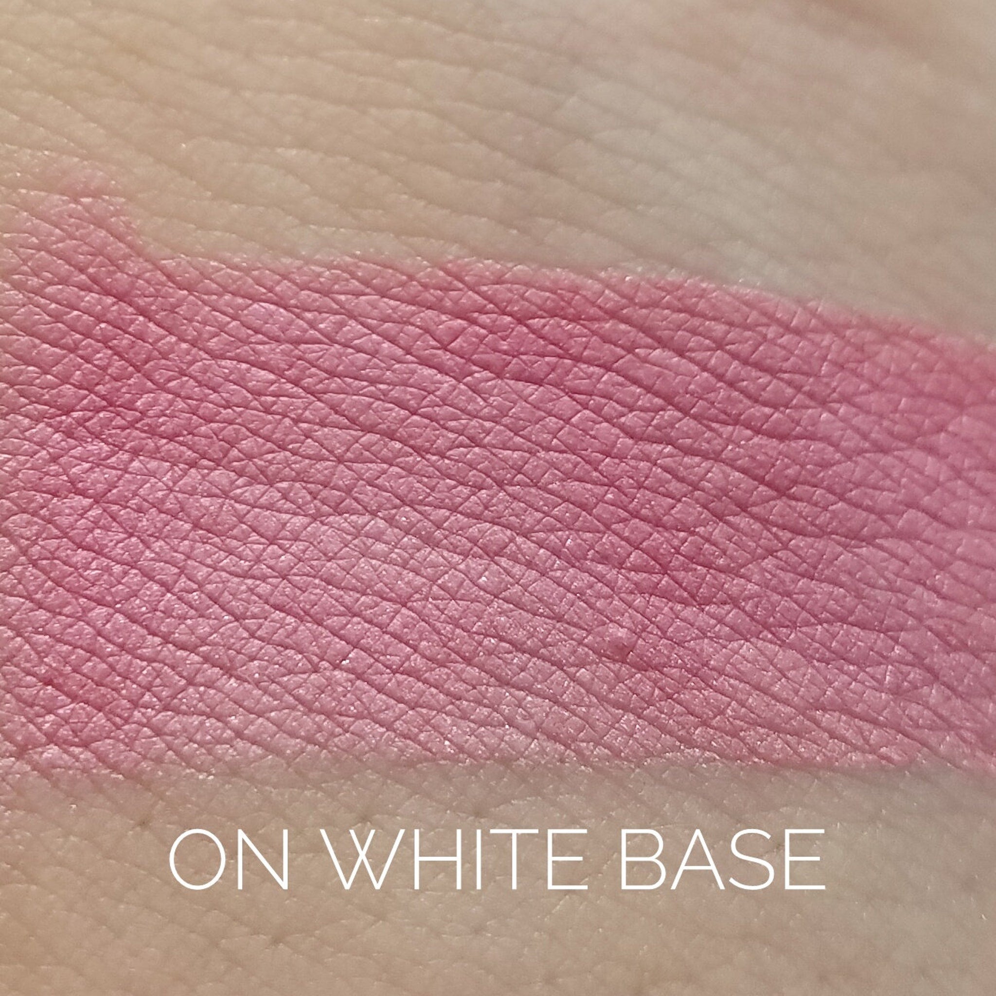 Close-up of rosy pink and bronze eye shadow palette with shimmering metallic finish and smooth powder texture