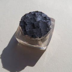 Close-up of navy blue loose powder eyeshadow with shimmer particles, showcasing fine mineral texture