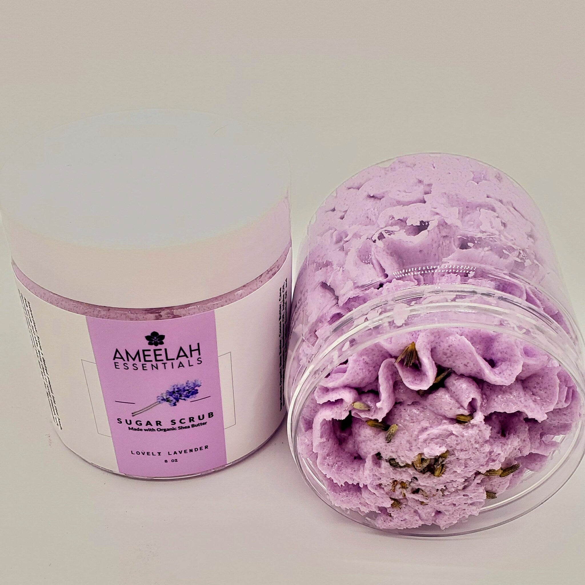Sugar scrub in lavender color with clear plastic container and Ameelah Essentials label visible
