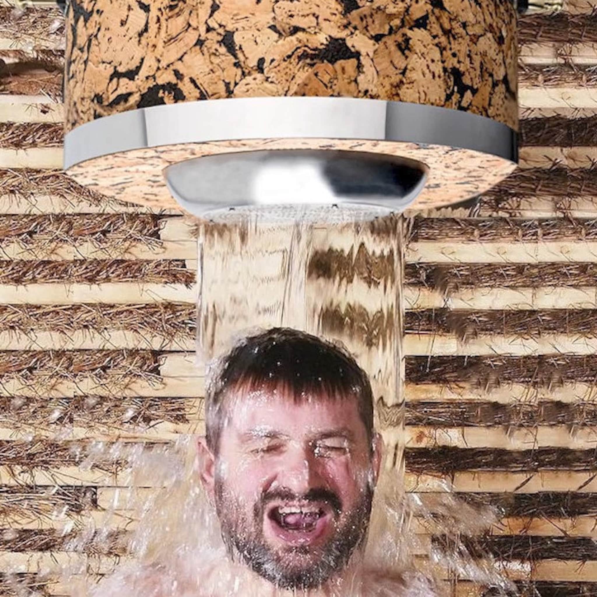Cork shower head with silver trim, water flowing onto person's head
