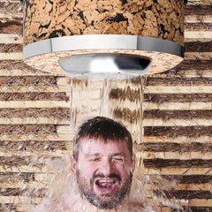 Cork shower head with silver trim, water flowing onto person's head