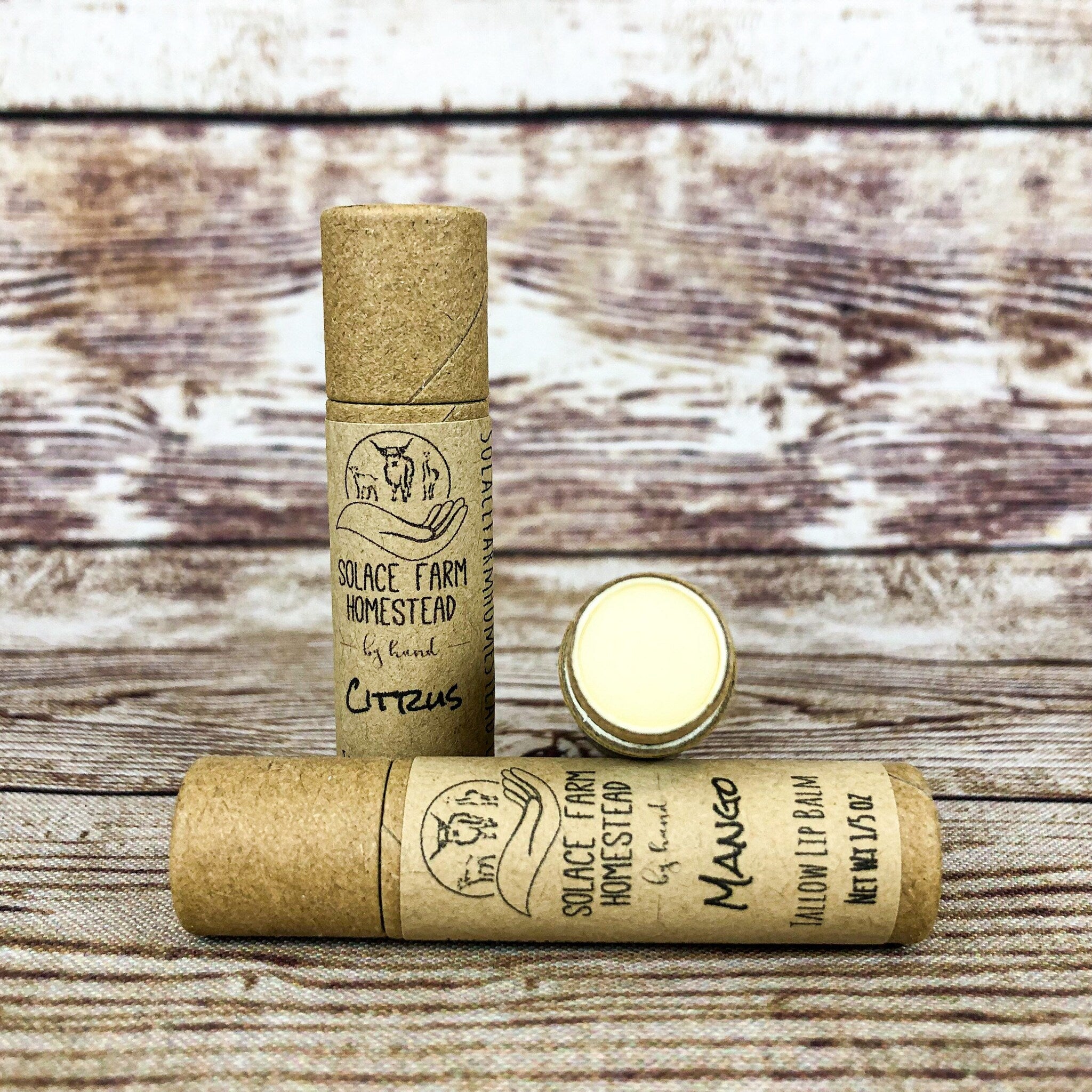 Lip balm tubes, brown cardboard, yellow balm, Solace Farm Homestead brand, citrus and mango flavors shown