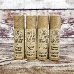 Lip balms in four brown paper tubes with Solace Farm Homestead brand text on them