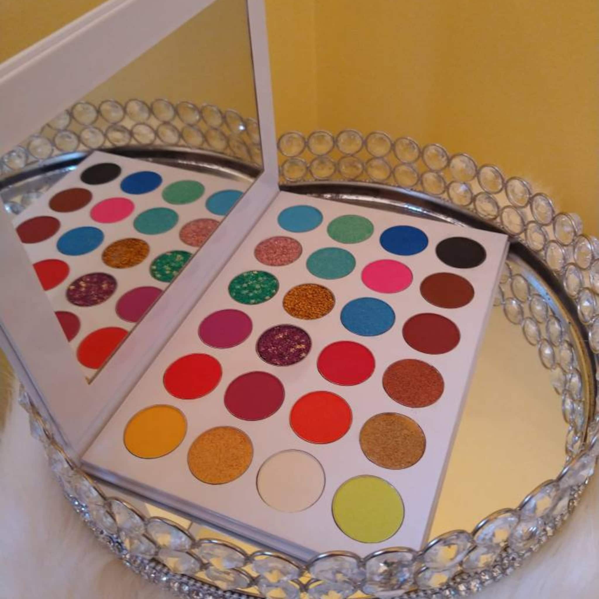Eyeshadow palette with colorful round eyeshadows, white background, and mirror reflection on a decorative tray