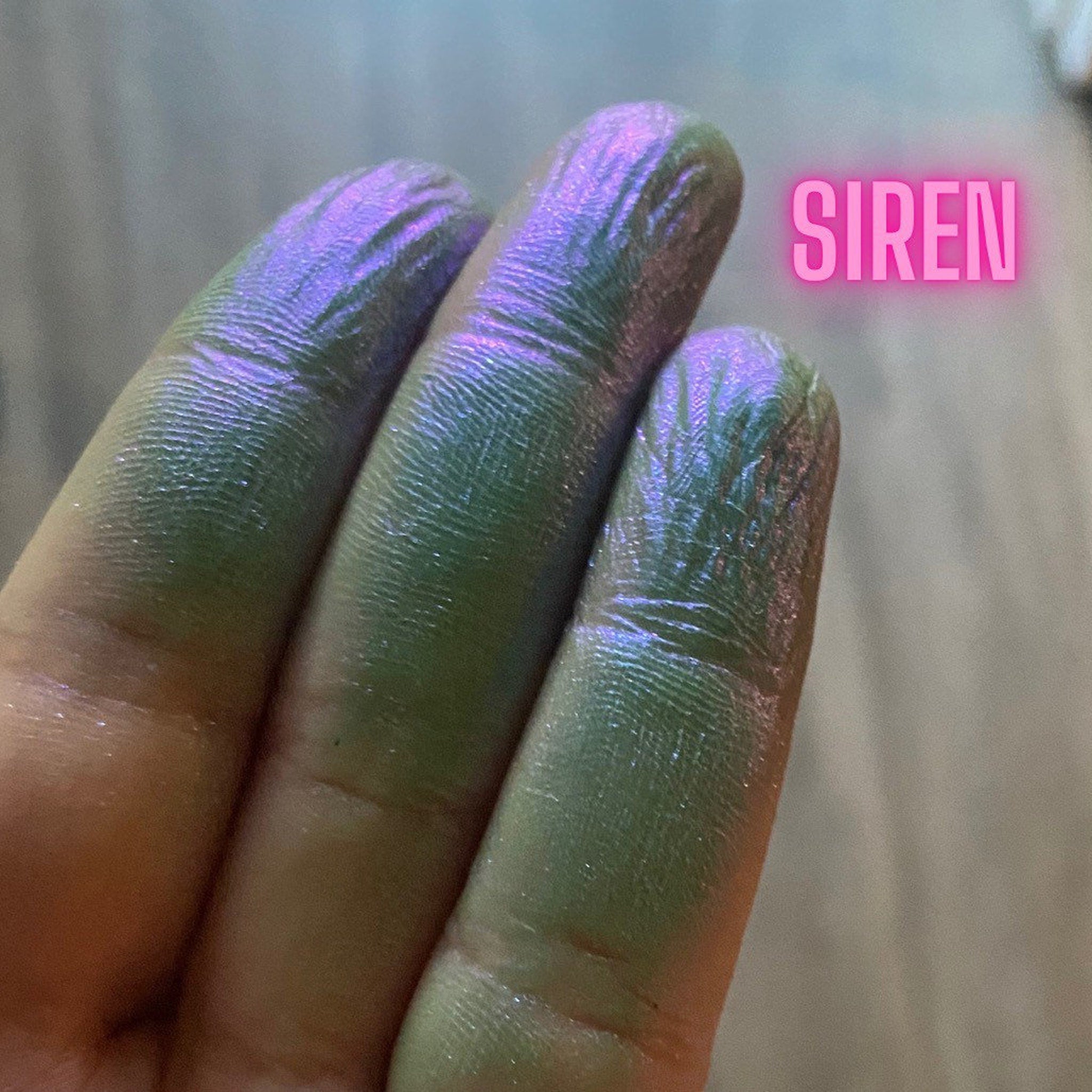 Close-up of multichrome eyeshadow palette showing shifting iridescent hues under light
