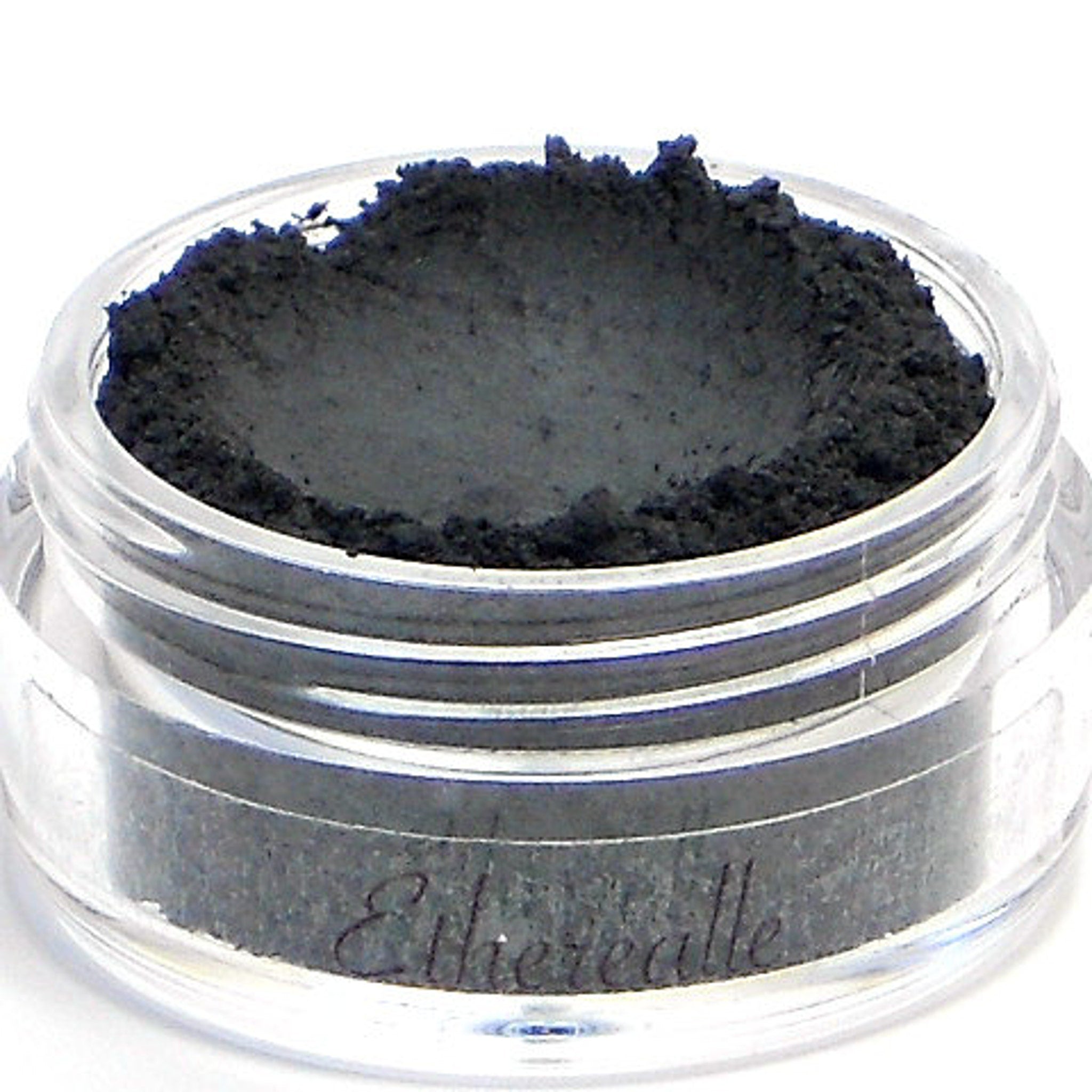 Side view of matte black vegan eyeshadow pan with Nero label, showcasing smooth mineral texture