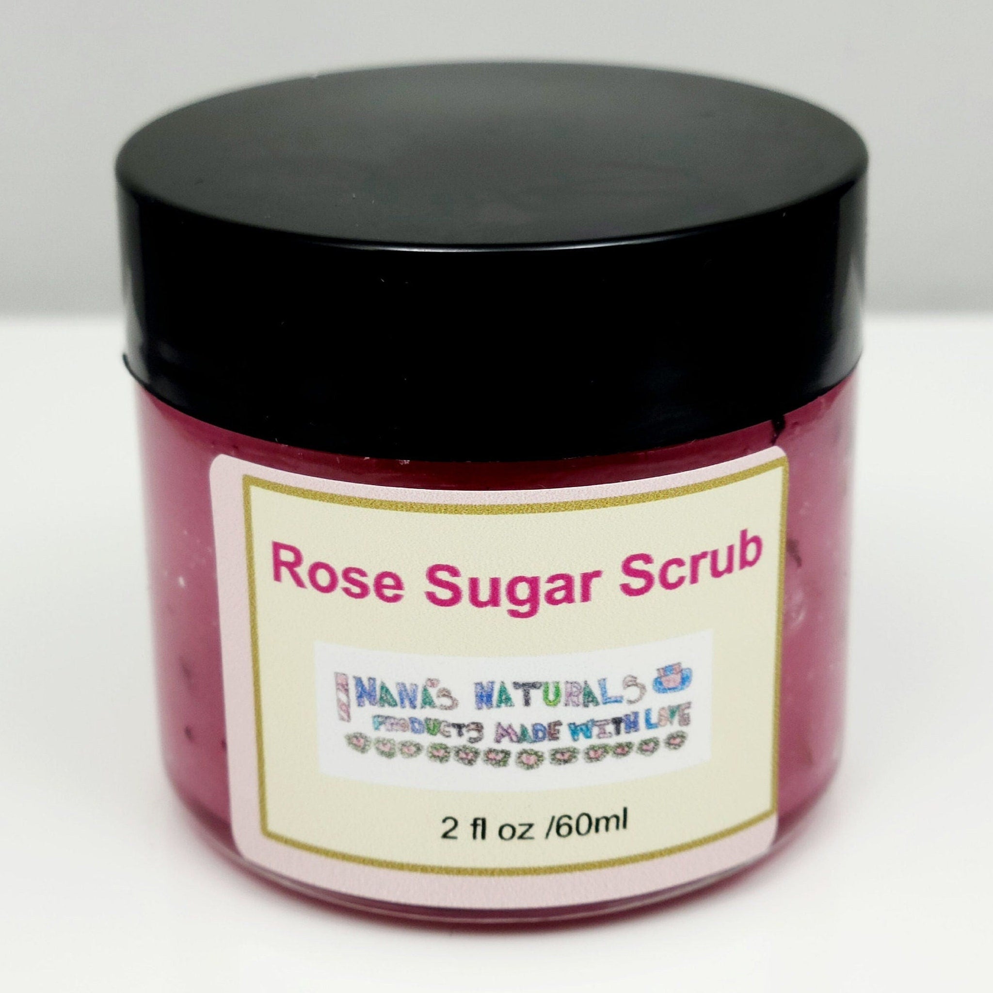 Rose sugar scrub jar, pink scrub, black lid, label reads Nanas Naturals, 2 fl oz size