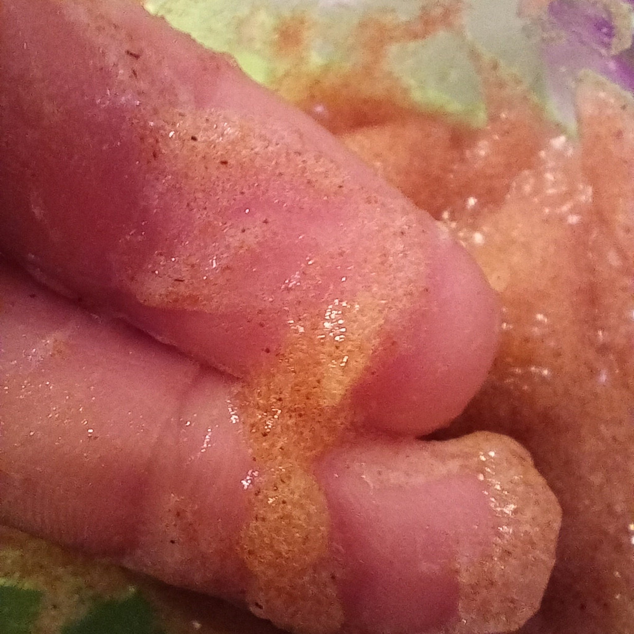 Skin with pink, brown, and tan tones, with a texture of small dots and bubbles