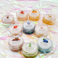 Lip scrub jars with various colors, labels, and ingredients, EYESEYEcreations brand visible