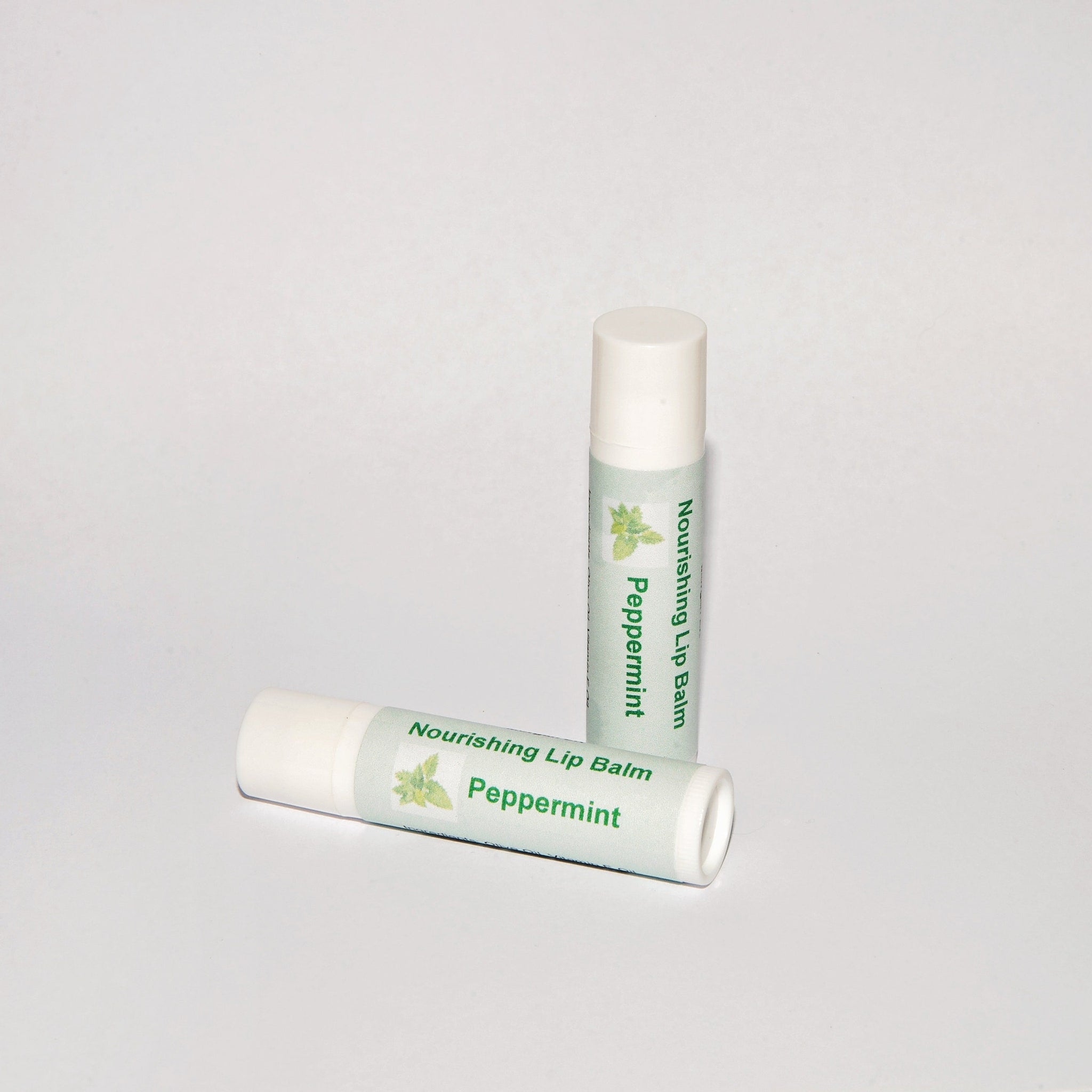 Lip balm tubes, white and green label with "Peppermint" text, on white background