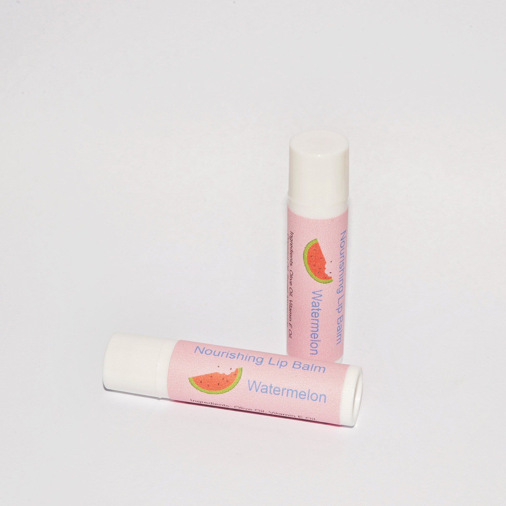 Lip balm tubes with pink label, watermelon graphic, and white tube body