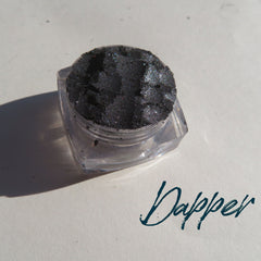 Black silver shimmer vegan mineral eyeshadow in loose powder form with cruelty-free label, displayed in open jar