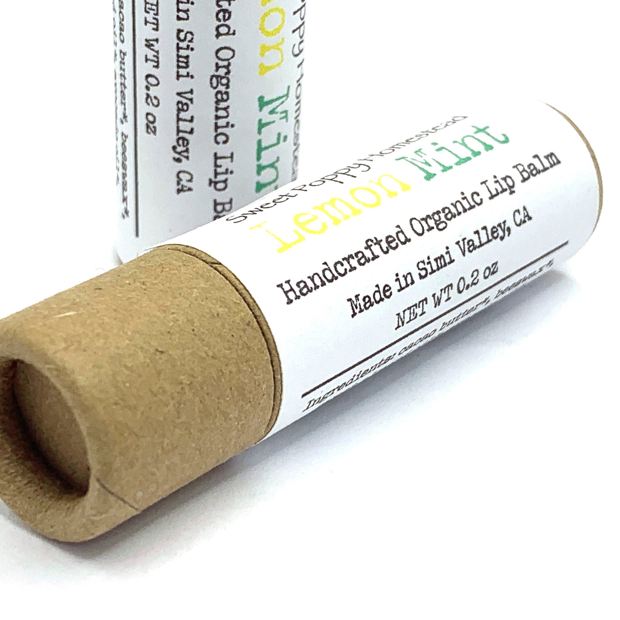 Lip balm tube with white label, brown cardboard, and Sweet Poppy Homestead text visible