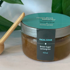 Facial scrub jar with teal label, brown contents, and wooden spoon, Manifest Beauty brand