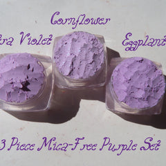 Three loose purple mica eyeshadow pigments in small jars with gold lids, vegan and cruelty-free mineral makeup.