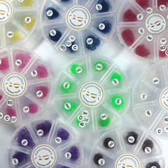 Colored eyelash extensions in various colors and lengths, Kimeyelashes brand visible in containers