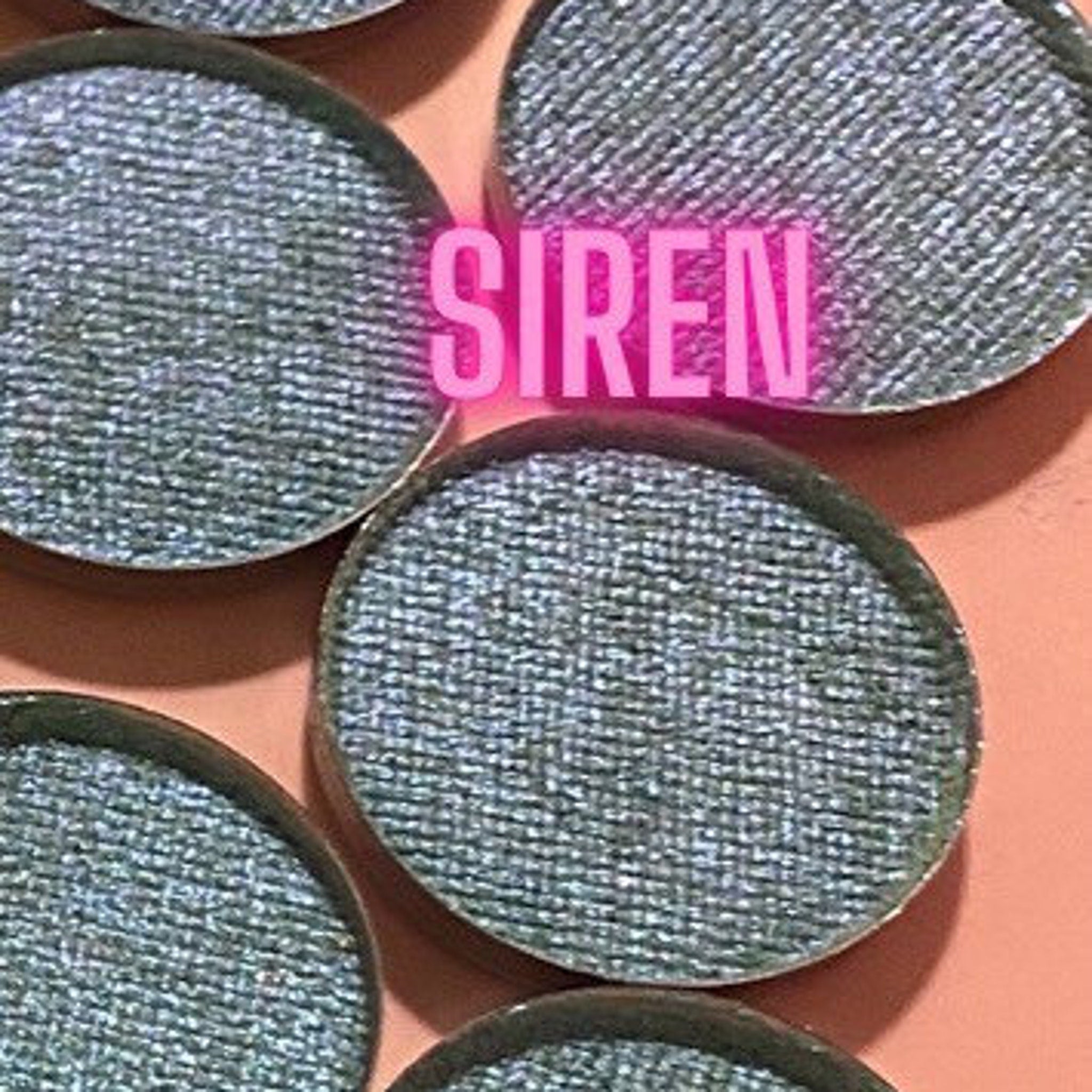 Open compact displaying five multichrome eyeshadows in shifting jewel tones with mirrored packaging.