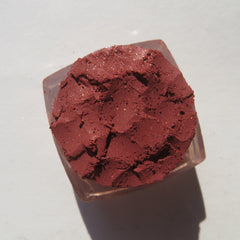 Side view of brick red-orange shimmer loose mineral eyeshadow with metallic finish in eco-friendly packaging