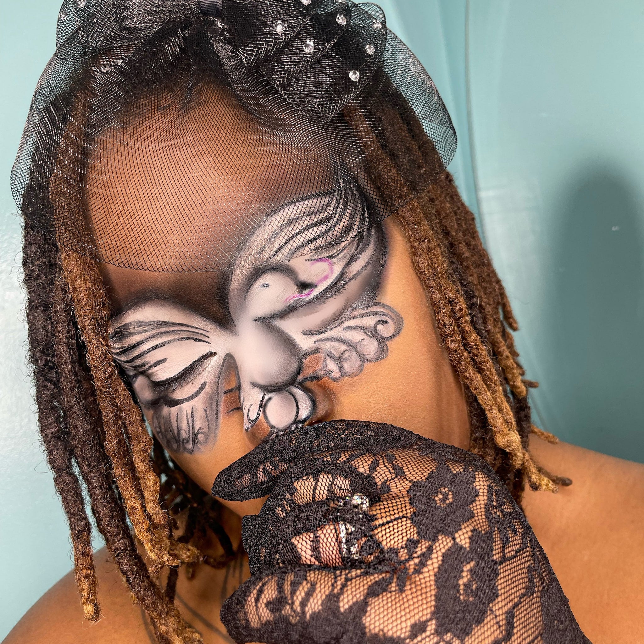 Face paint dove design with black and white color scheme, black lace glove, and black veil with rhinestones