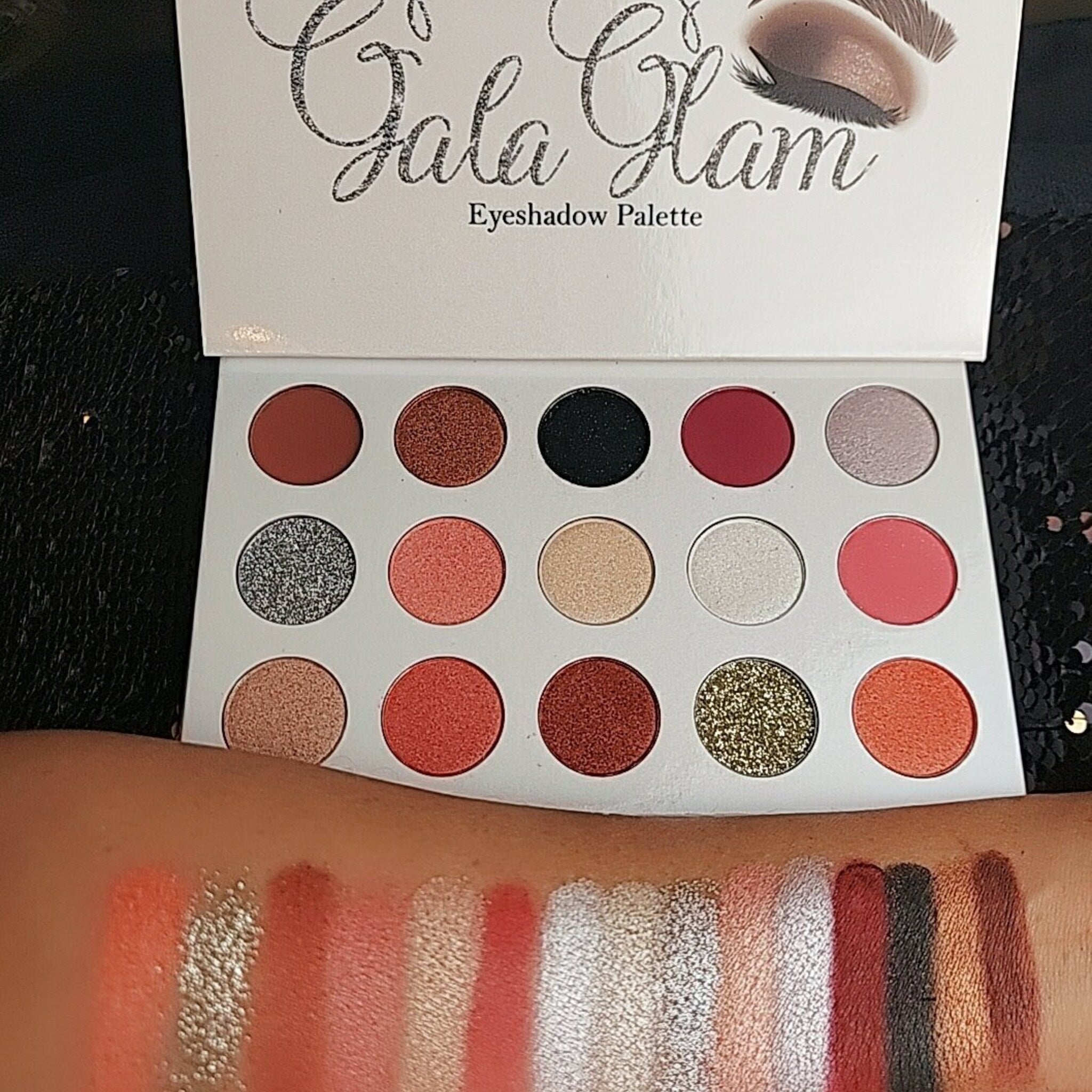 Alluring Faces Gala Glam Eyeshadow Palette displayed open, showcasing 12 vibrant shimmer and matte shades in sleek black compact