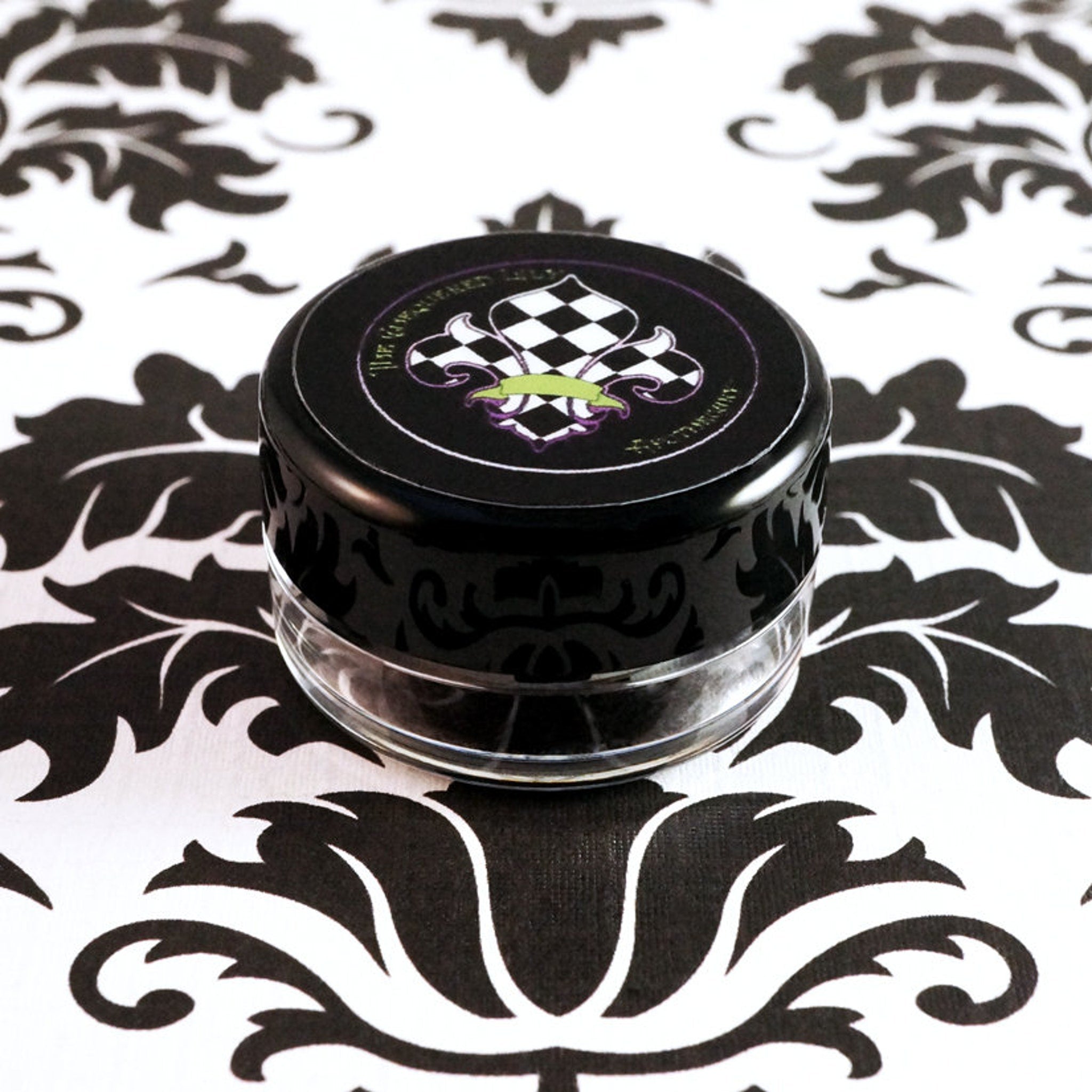 Dark purple loose mineral eyeshadow spilled on marble surface with brush for application