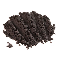 Close-up of matte dusty violet loose pigment eyeshadow with dark purple-gray hue in minimalist packaging