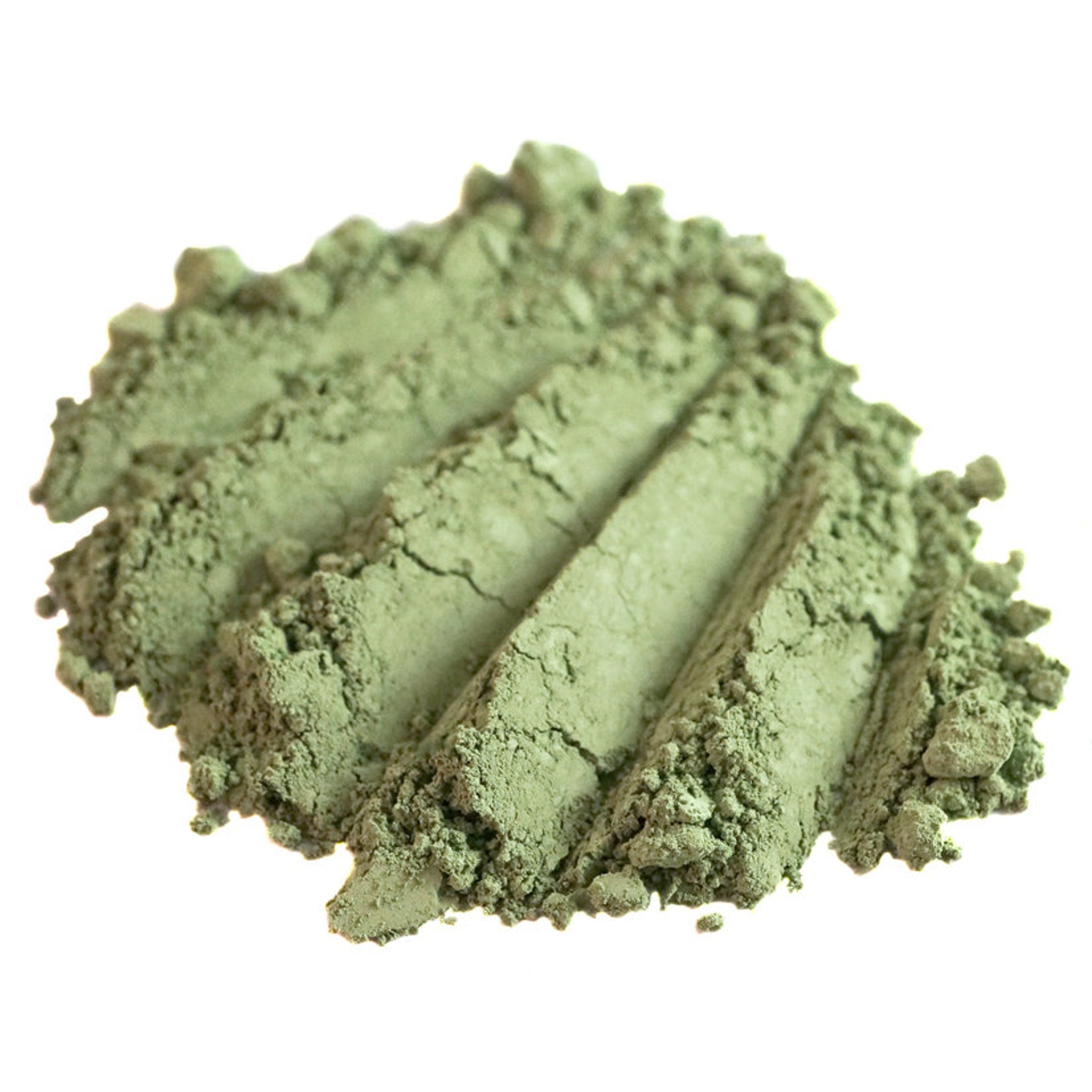 Hand applying matte sage green loose mineral eyeshadow with brush, showcasing olive shade from Withered Garden collection