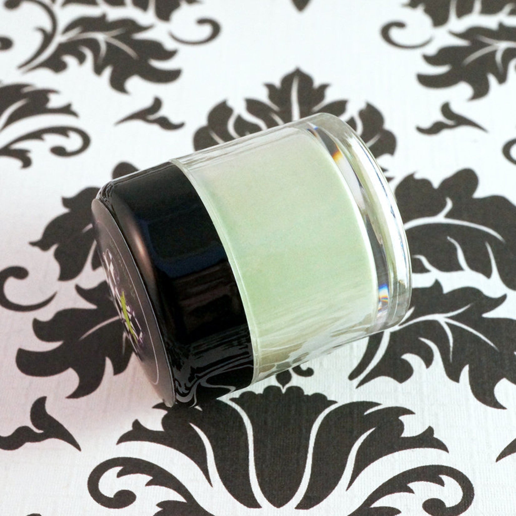 Close-up of loose mineral eyeshadow in matte sage green shade with fine powder texture