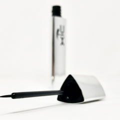 Liquid eyeliner, black applicator with fine tip, silver tube with XiC text visible